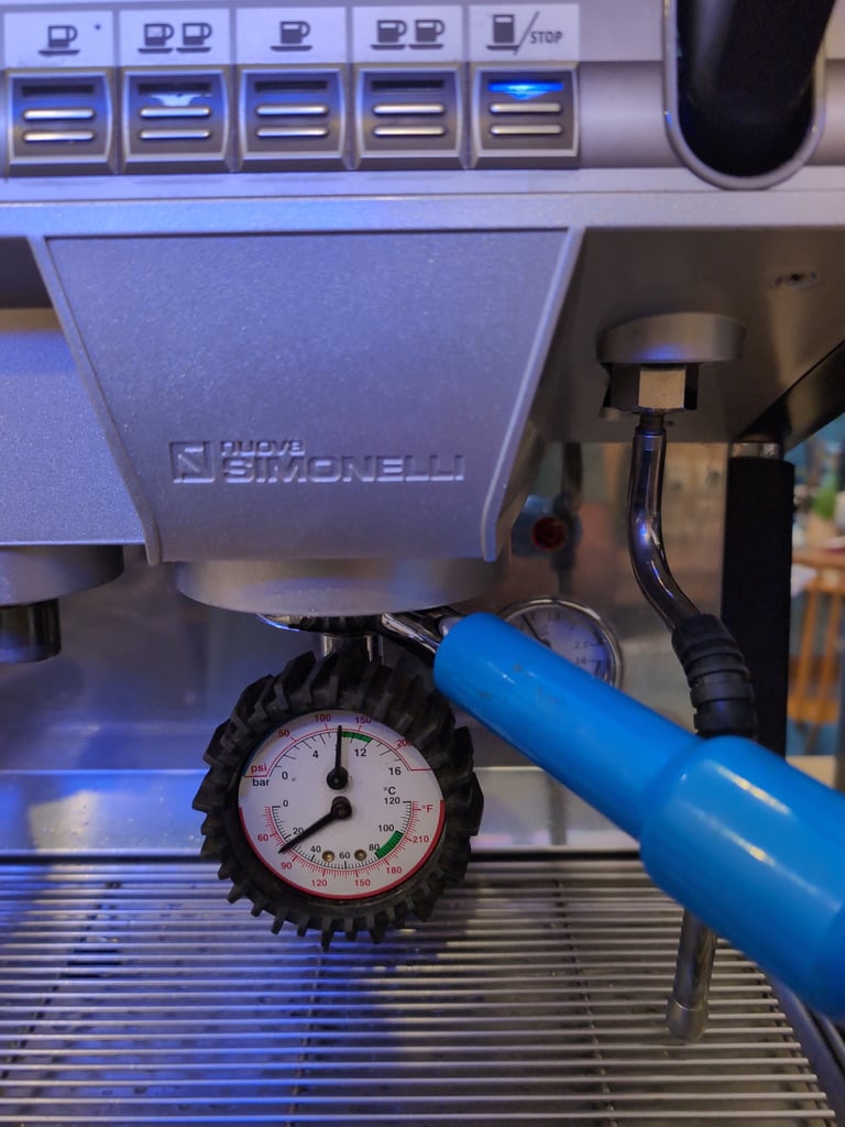 Skupinová hlava Nuova Simonelli s manometrem během údržby a kontroly tlaku v kavárně